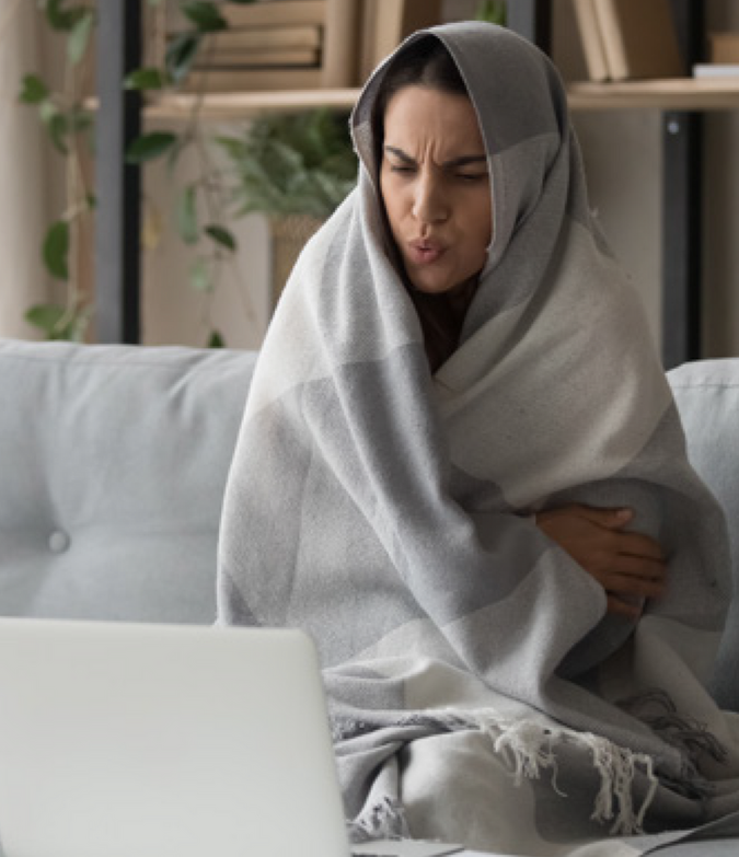 Woman with blanket on using laptop_